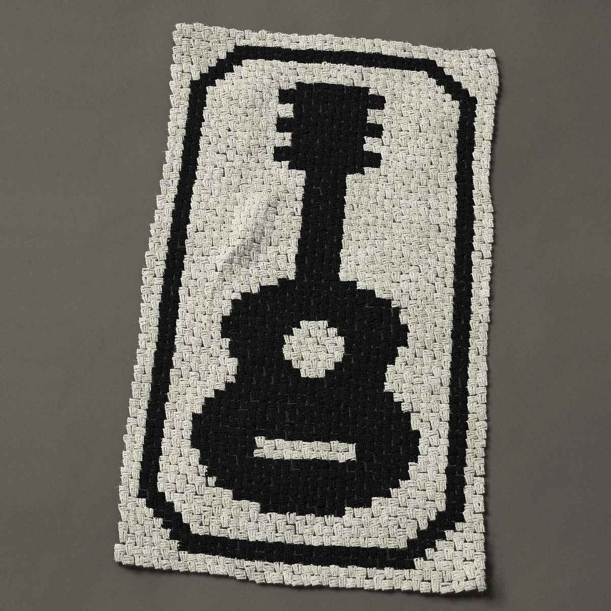 A baby blanket worked corner to corner, 29¼ by 50 inches: Black acoustic guitar silhouette in a frame, one color, 39 by 67 blocks
