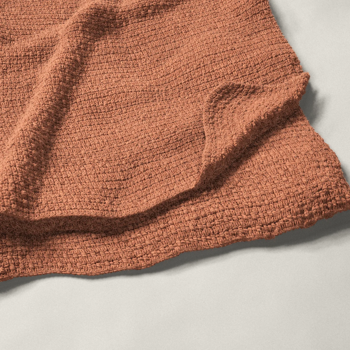 A throw in aligned cobble stitch, 50¼ by 60¼ inches, folded in half with a corner turned back