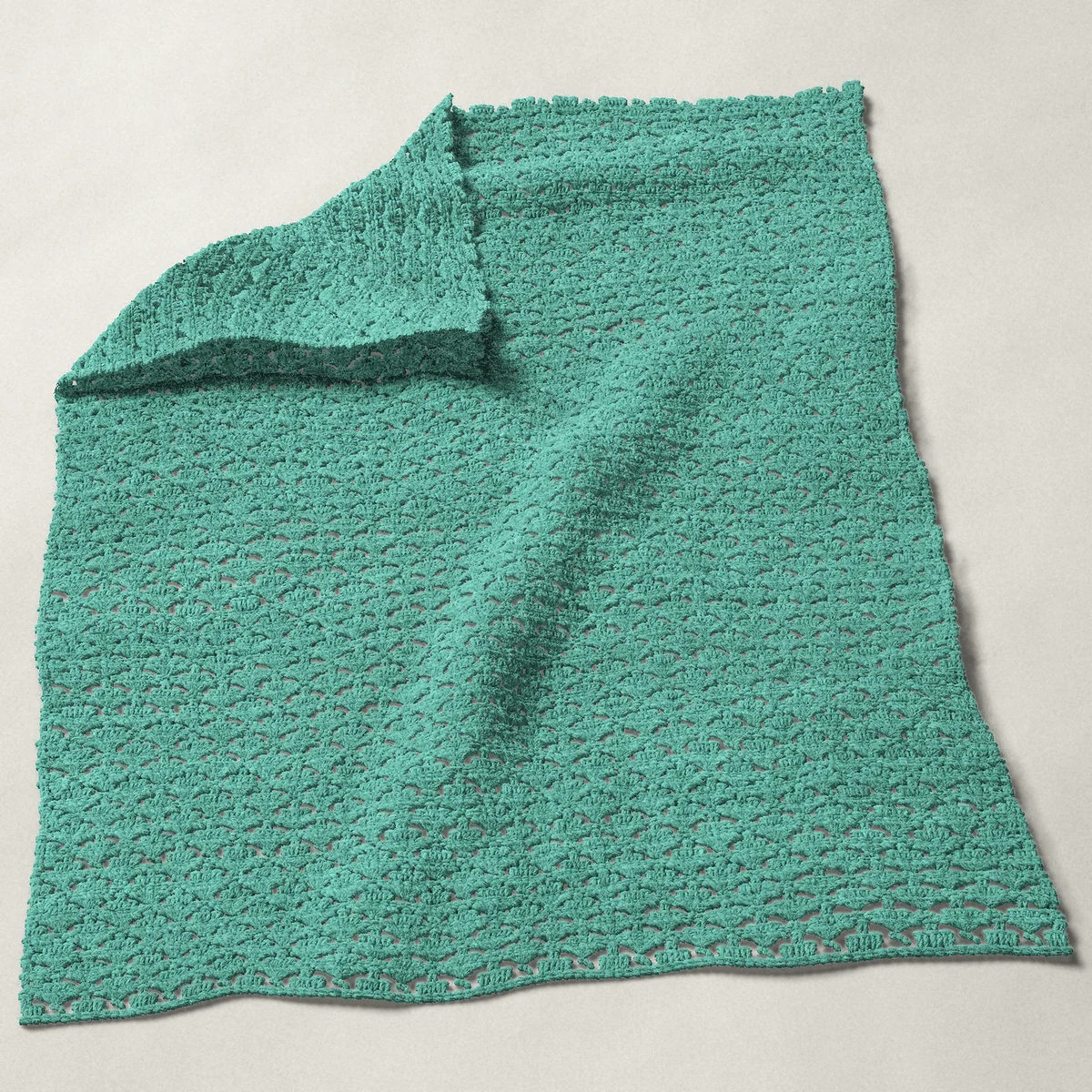 A baby blanket in arcade stitch, 31¾ by 39½ inches, spread out with a corner turned over