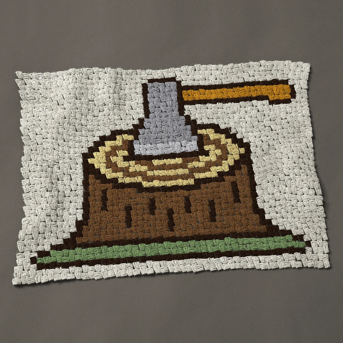 A baby blanket worked corner to corner, 37½ by 28½ inches: Stump and axe: an axe stuck in a tree stump, 50 by 38 blocks