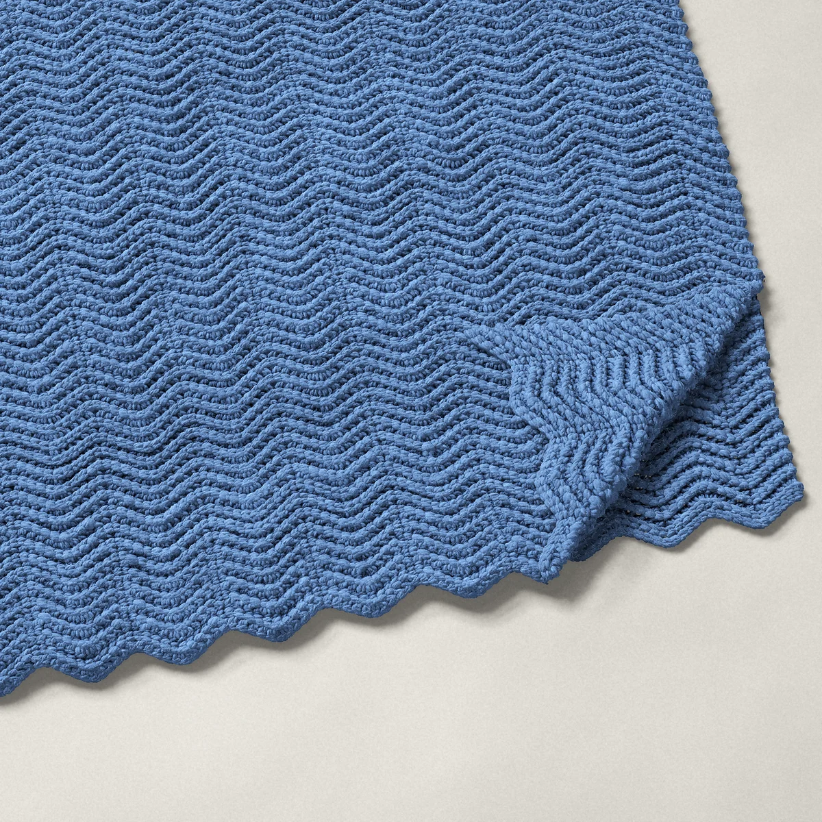 A throw in back loop single crochet ripple, 51½ by 60 inches, folded in half with a corner turned back