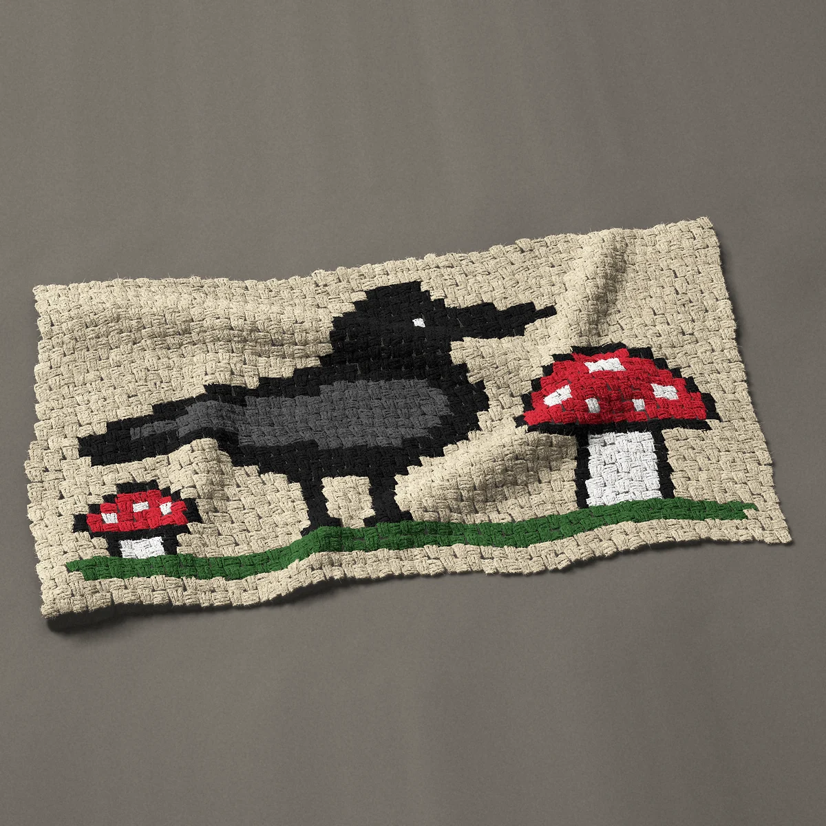 A baby blanket worked corner to corner, 43½ by 24¾ inches: Crow with mushrooms: a black crow among red toadstools, 58 by 33 blocks