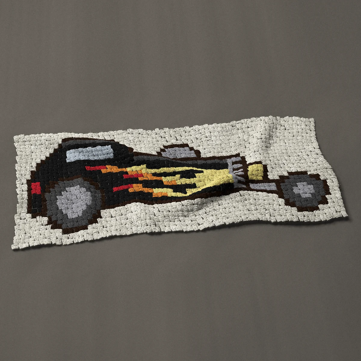 A panel worked corner to corner, 49½ by 20¼ inches: Black hot rod with flames and a big rear wheel, 66 by 27 blocks