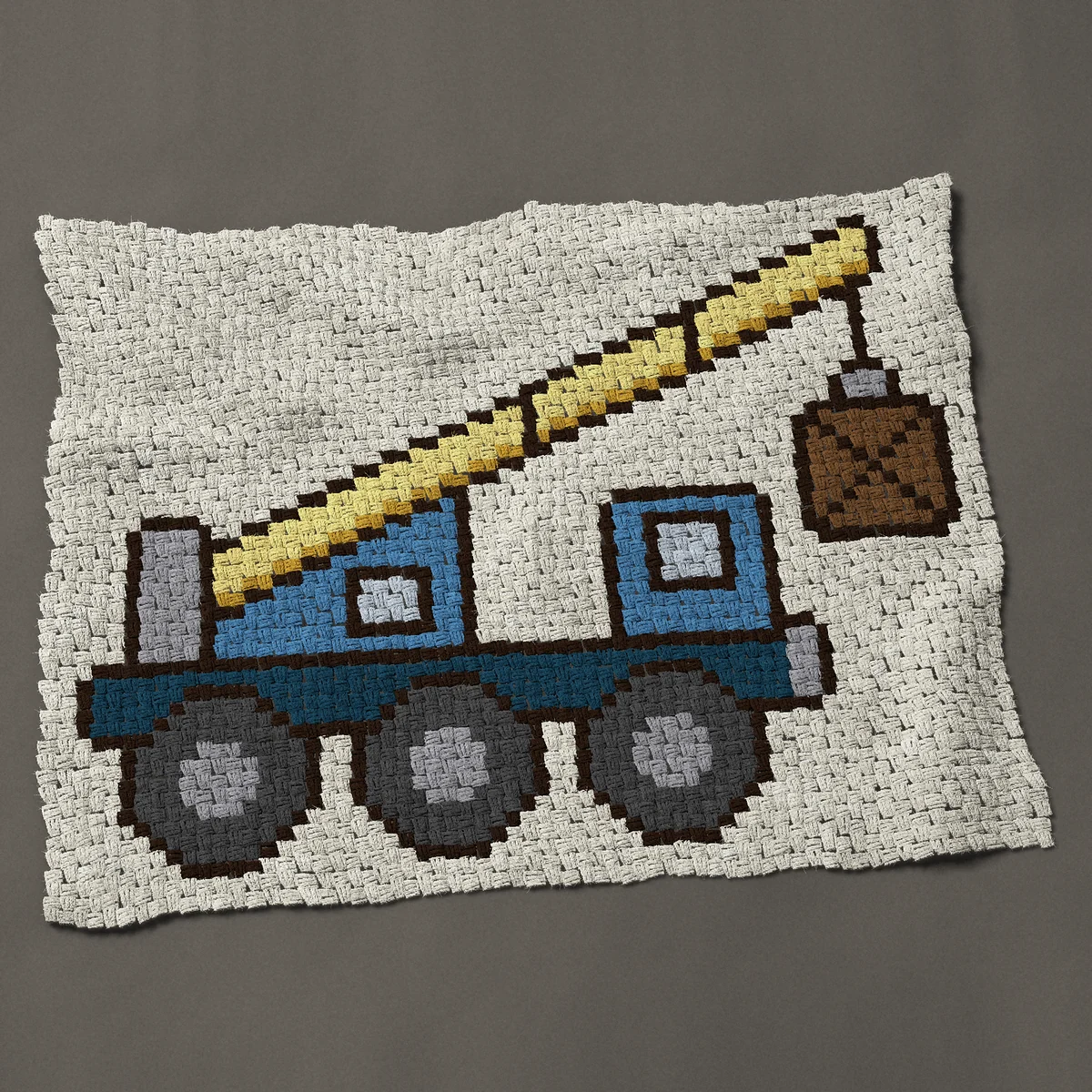 A baby blanket worked corner to corner, 48½ by 38 inches: Blue construction crane truck lifting a wooden crate, 65 by 51 blocks