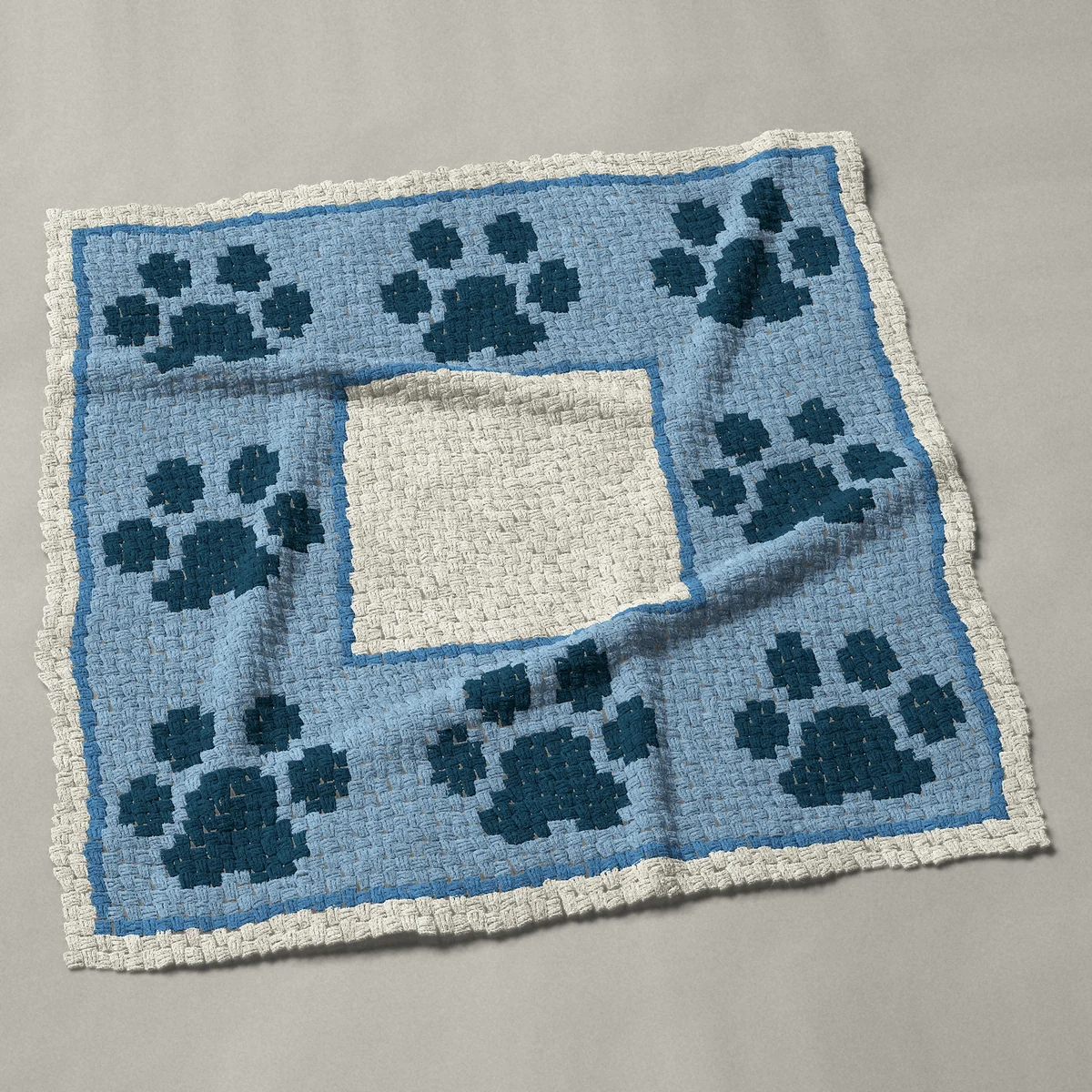 A throw worked corner to corner, 51 by 51 inches: Blue paw print border frame with eight paw prints, 68 by 68 blocks