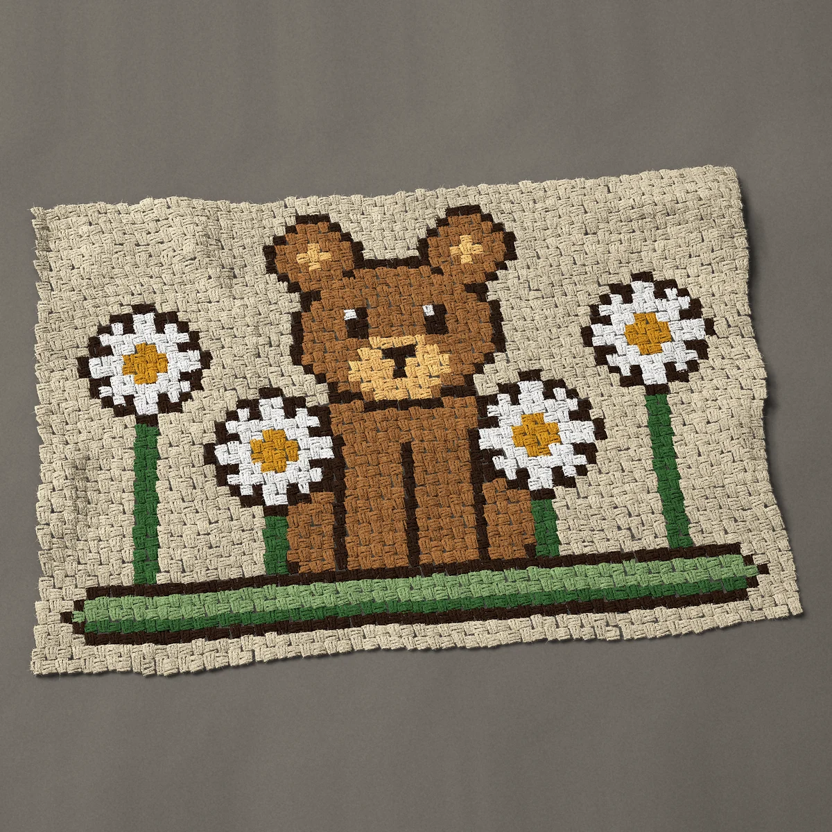 A baby blanket worked corner to corner, 47 by 32¼ inches: Bear with daisies: a brown bear sitting among flowers, 63 by 43 blocks