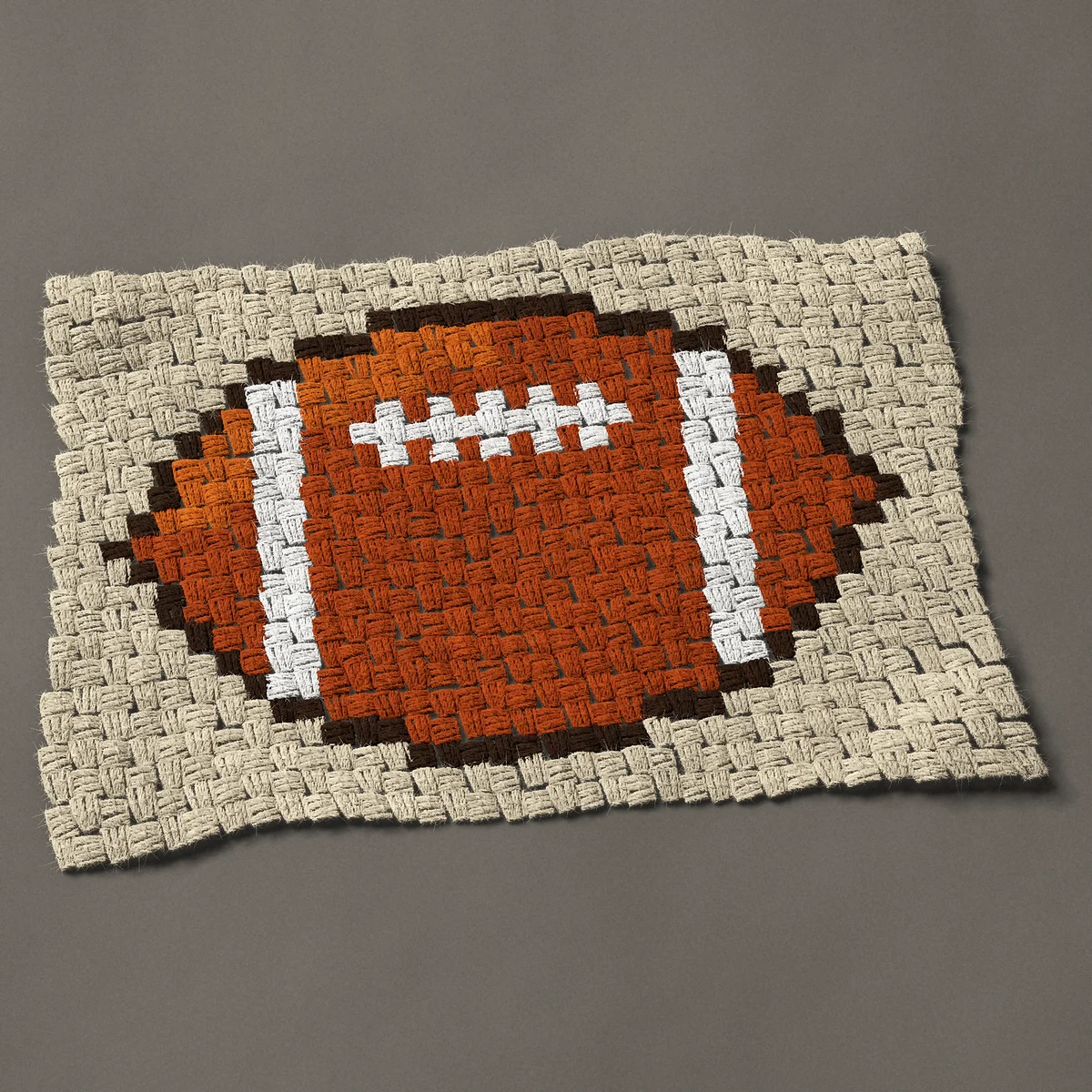 A panel worked corner to corner, 26¼ by 17¼ inches: American football with white laces, 35 by 23 blocks