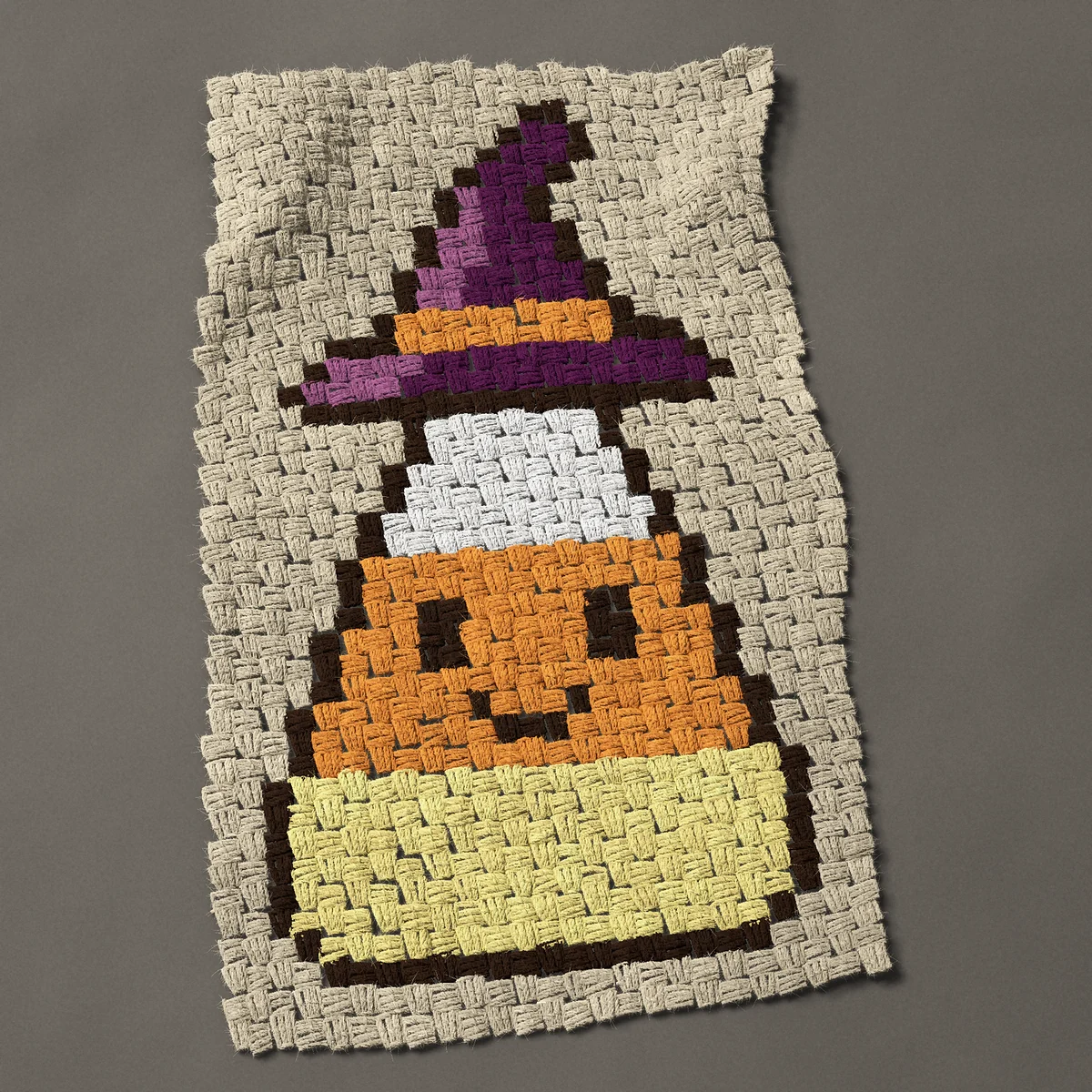 A panel worked corner to corner, 18¾ by 31½ inches: Cute candy corn in a purple witch hat, 25 by 42 blocks