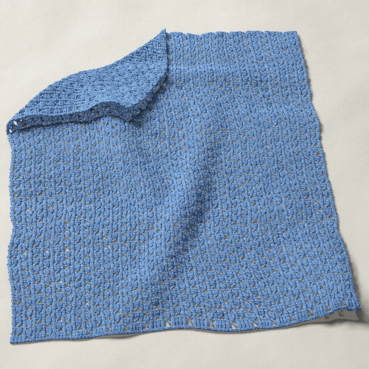 A baby blanket in checkerboard mesh, 32½ by 40 inches, spread out with a corner turned over