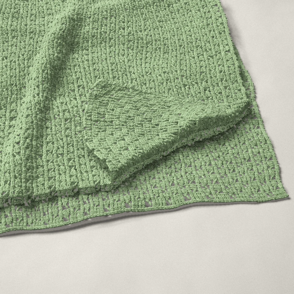 A throw in checkerboard mesh, 54¾ by 65½ inches, folded in half with a corner turned back