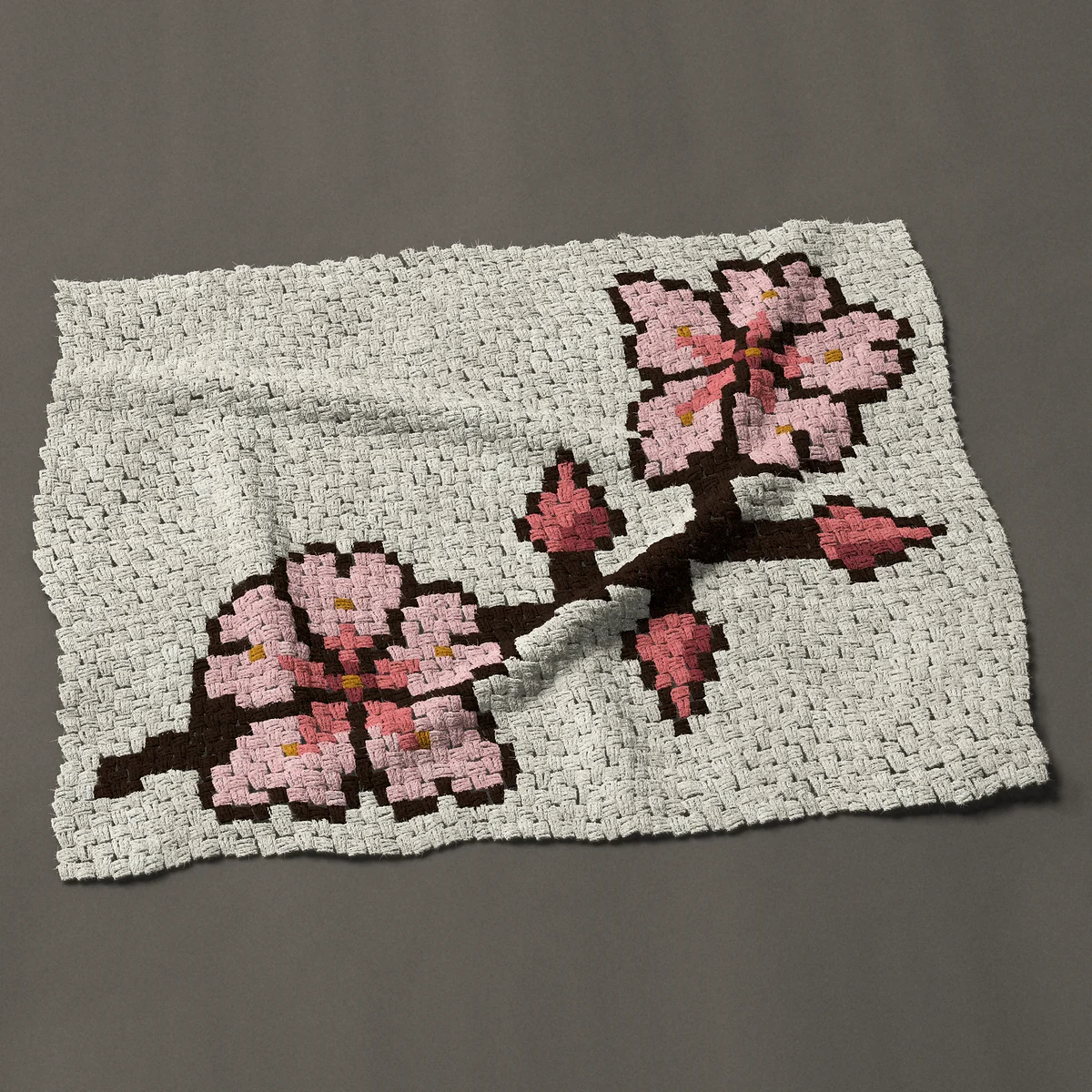 A baby blanket worked corner to corner, 45½ by 35¼ inches: Cherry blossom branch with two blossoms and three buds, 61 by 47 blocks