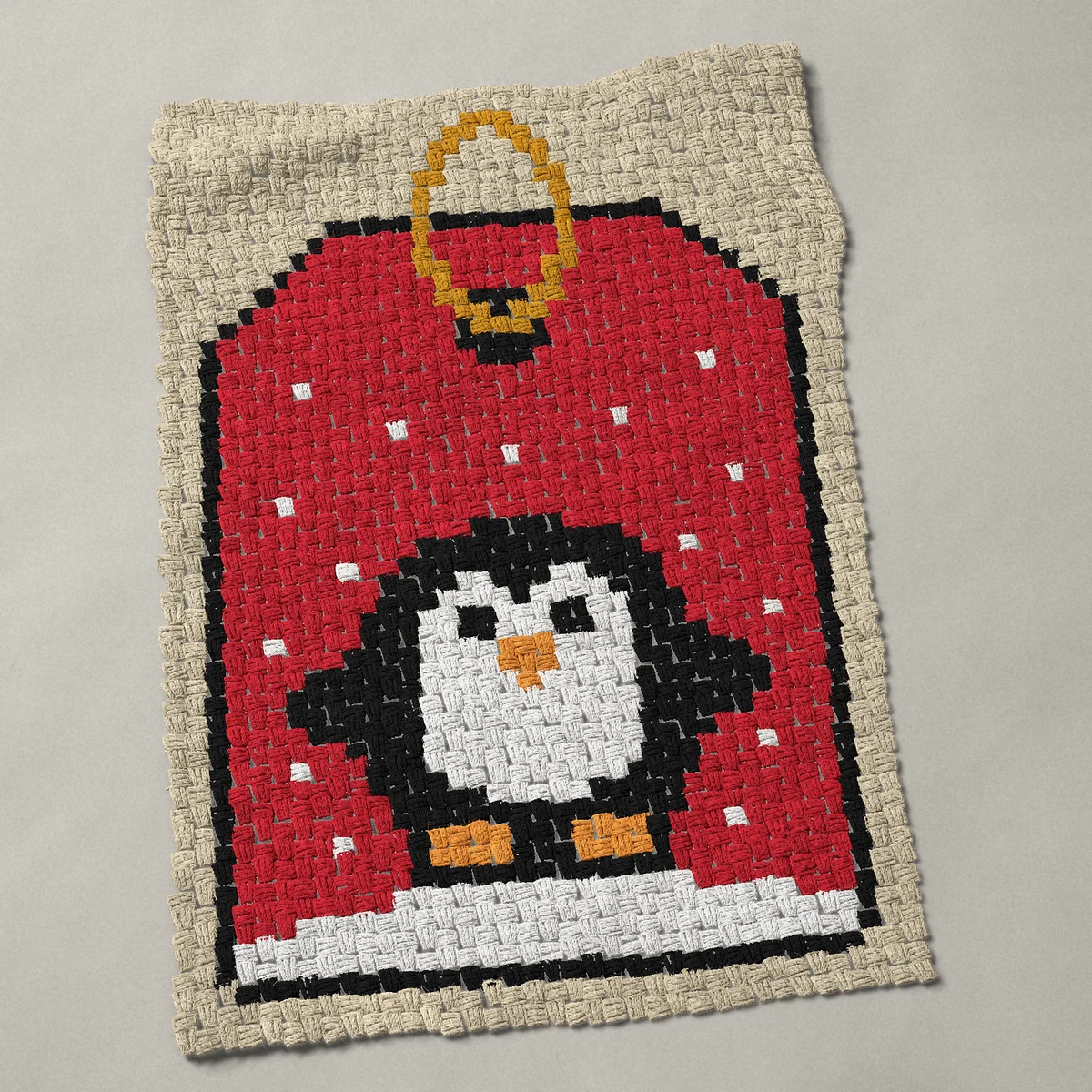 A baby blanket worked corner to corner, 27¾ by 41 inches: Christmas gift tag with a penguin in the snow, 37 by 55 blocks