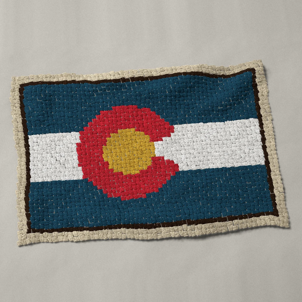 A baby blanket worked corner to corner, 45 by 31½ inches: Colorado state flag with the red C and gold disc, 60 by 42 blocks