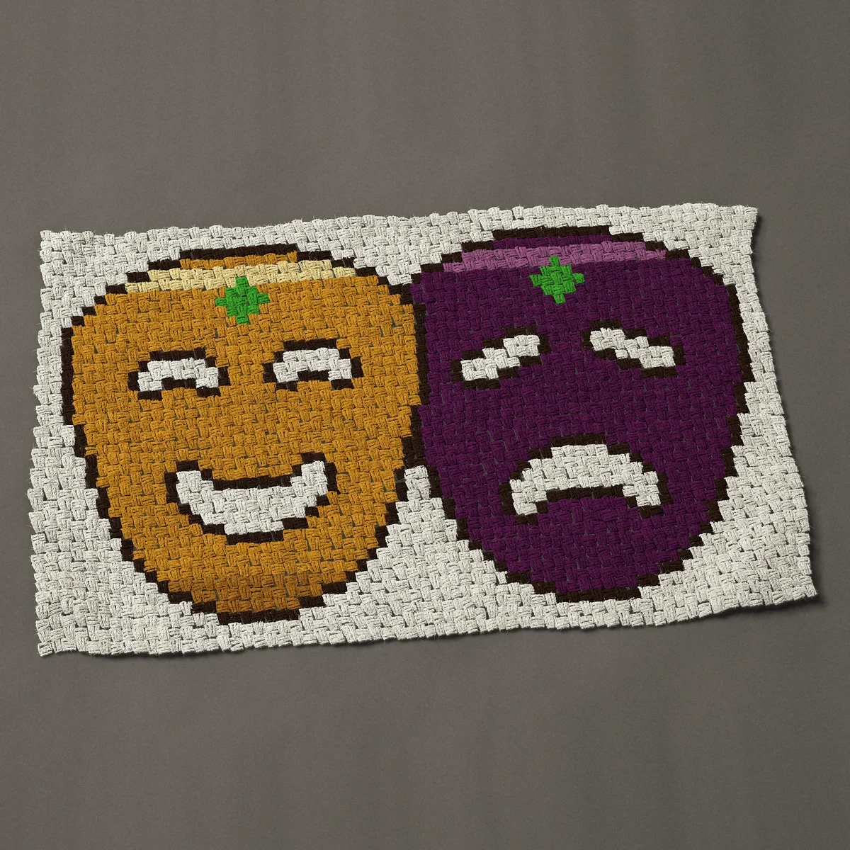 A baby blanket worked corner to corner, 49½ by 30 inches: Comedy and tragedy theatre masks in Mardi Gras colors, 66 by 40 blocks