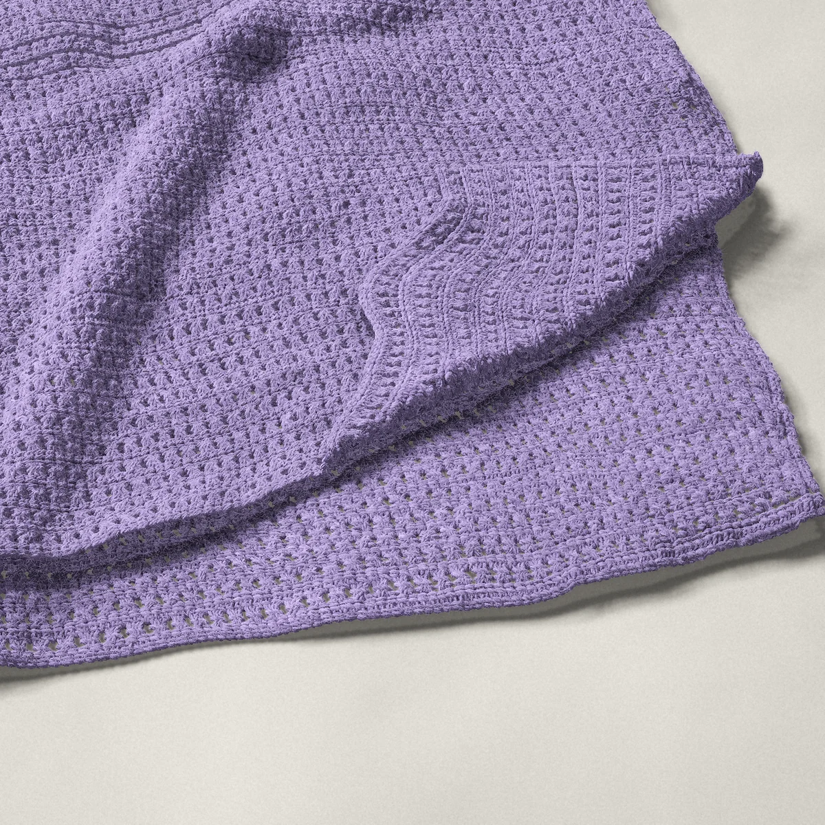 A throw in crossed double crochet, 54¼ by 66 inches, folded in half with a corner turned back