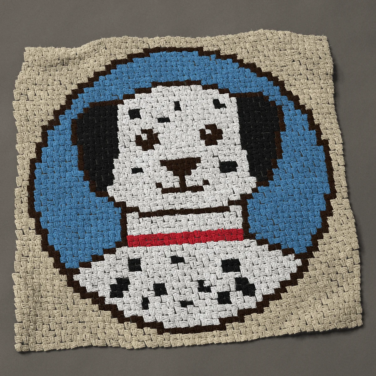 A baby blanket worked corner to corner, 41 by 41 inches: Dalmatian dog face with a red collar in a blue round, 55 by 55 blocks