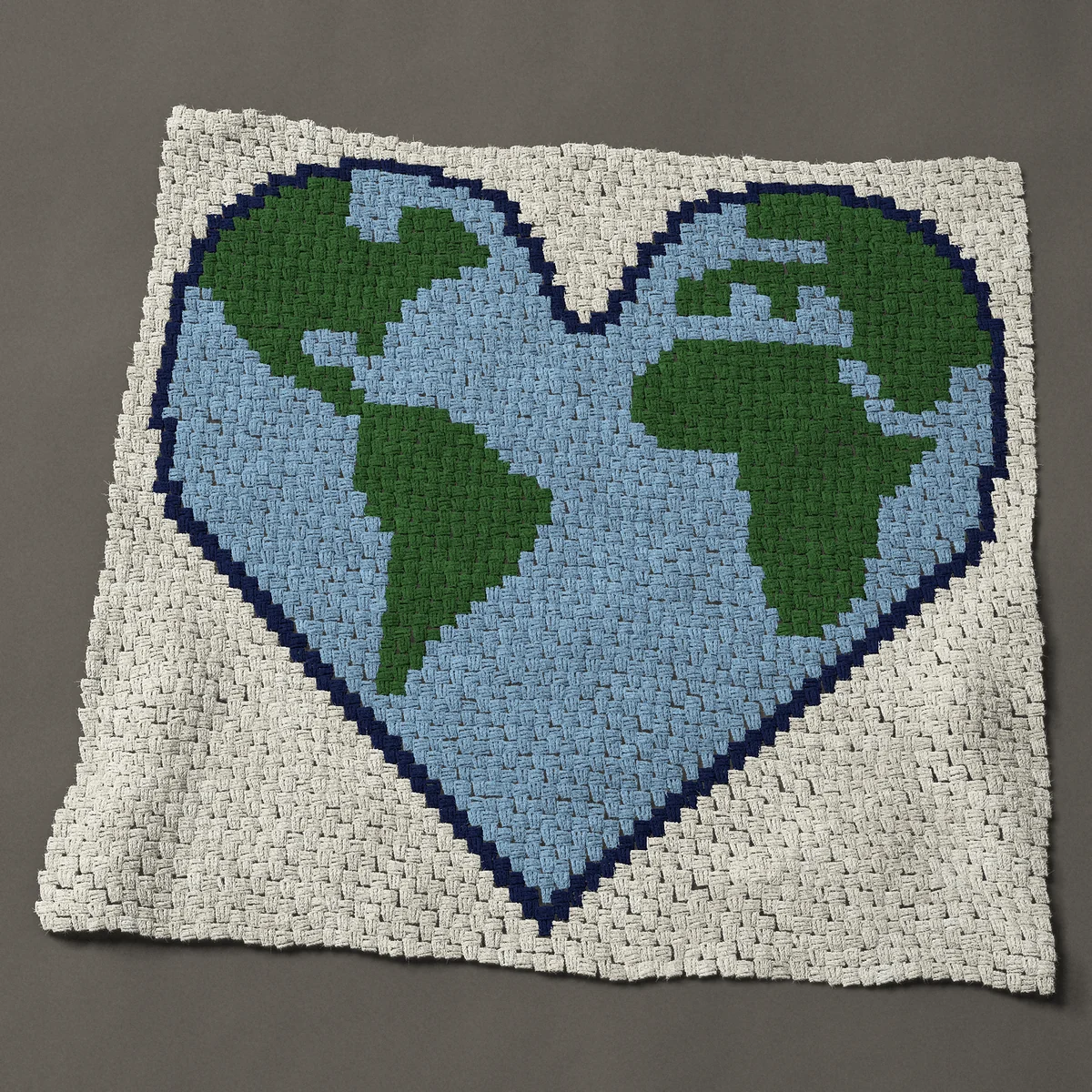 A panel worked corner to corner, 48½ by 47 inches: Heart-shaped Earth with green continents and blue sea, 65 by 63 blocks