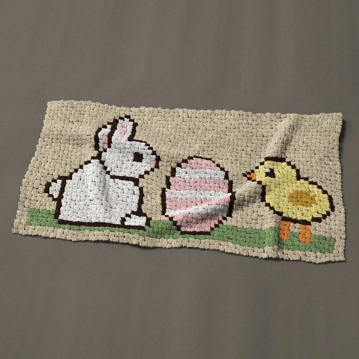 A baby blanket worked corner to corner, 51 by 27¾ inches: Easter bunny and chick with a striped egg, 68 by 37 blocks