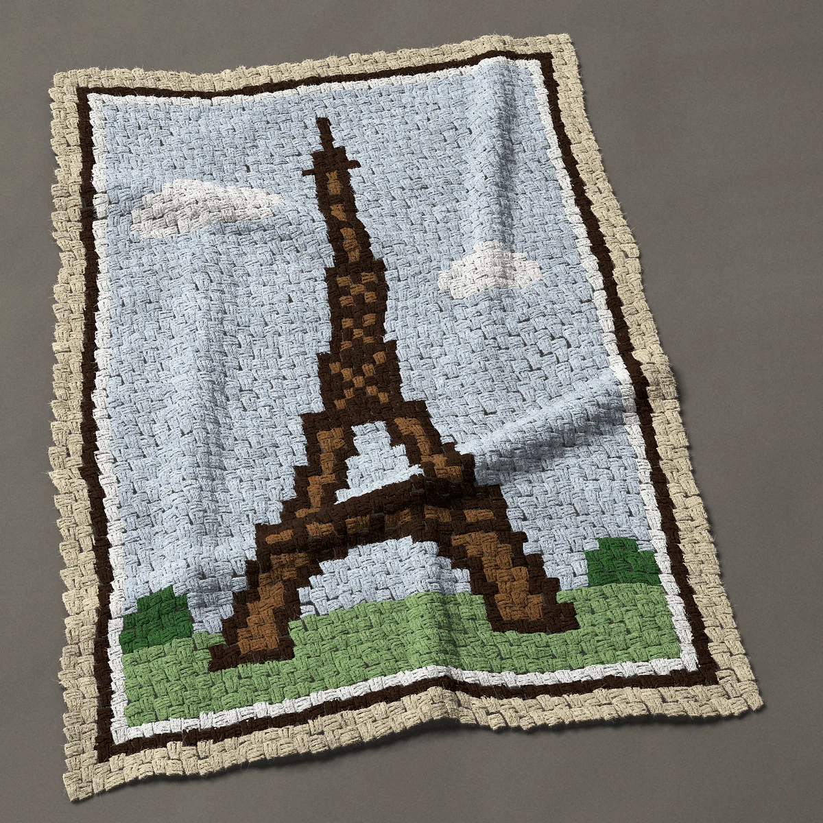 A baby blanket worked corner to corner, 35¼ by 51 inches: Eiffel Tower in Paris against a blue sky, framed, 47 by 68 blocks