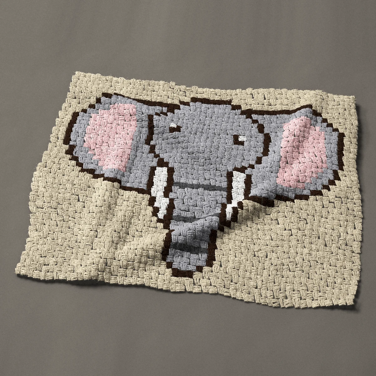 A baby blanket worked corner to corner, 38 by 30¾ inches: Elephant face with big pink ears and white tusks, 51 by 41 blocks
