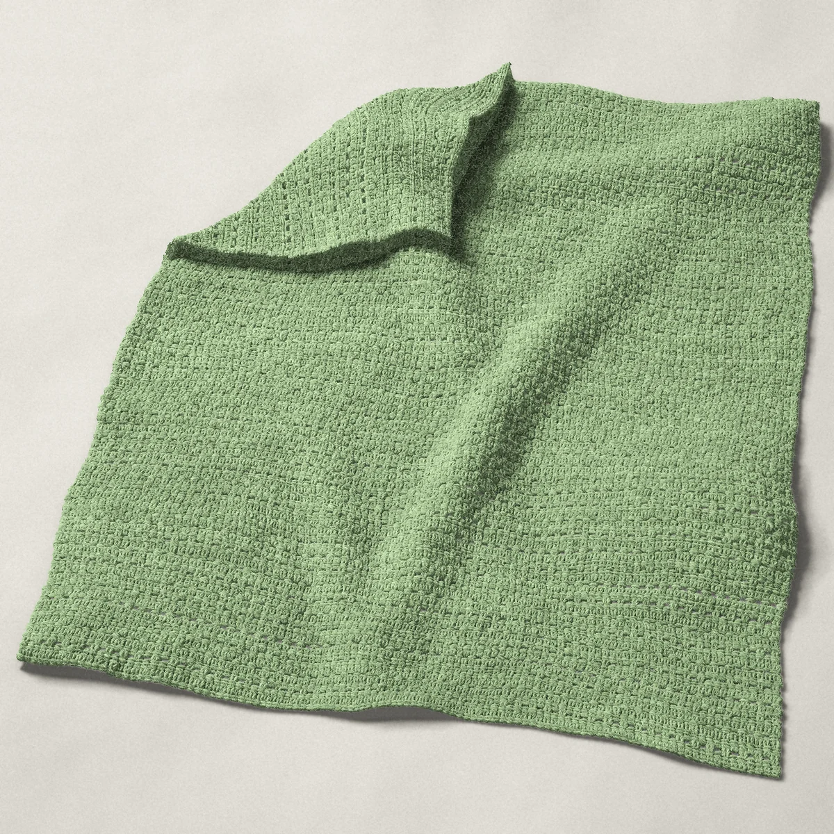 A baby blanket in single crochet eyelet rows, 32¼ by 39¾ inches, spread out with a corner turned over