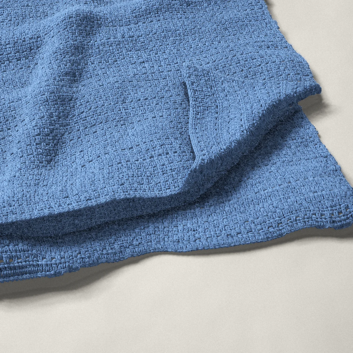 A throw in single crochet eyelet rows, 50¼ by 60 inches, folded in half with a corner turned back