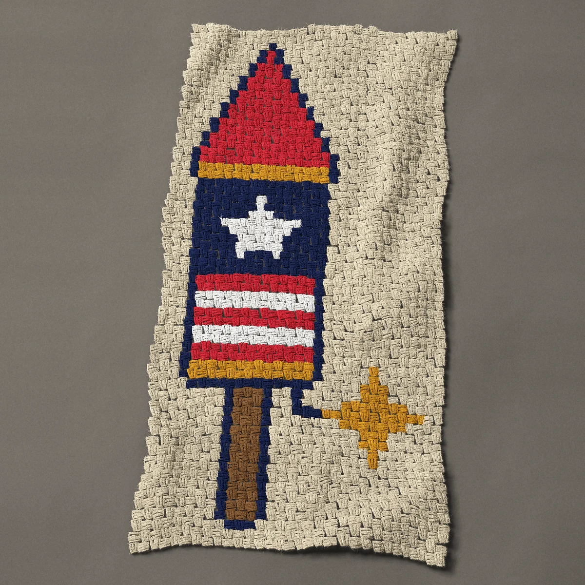 A panel worked corner to corner, 23¼ by 47 inches: 4th of July firework rocket with a star and stripes, 31 by 63 blocks