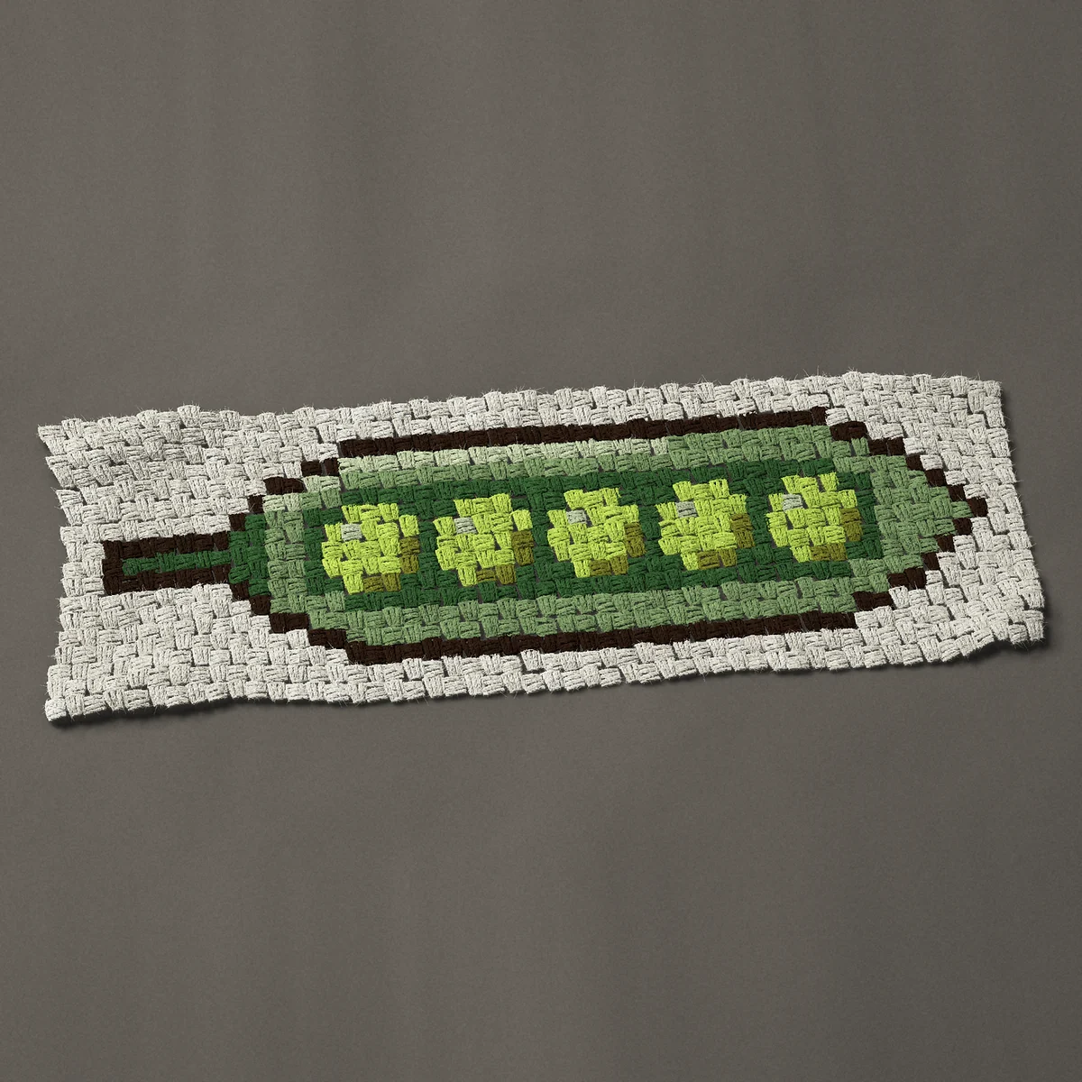 A panel worked corner to corner, 39 by 12¾ inches: Five green peas in an open pea pod, 52 by 17 blocks
