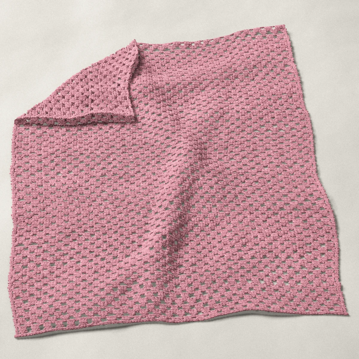 A baby blanket in granny groups and chains, 32¼ by 40 inches, spread out with a corner turned over