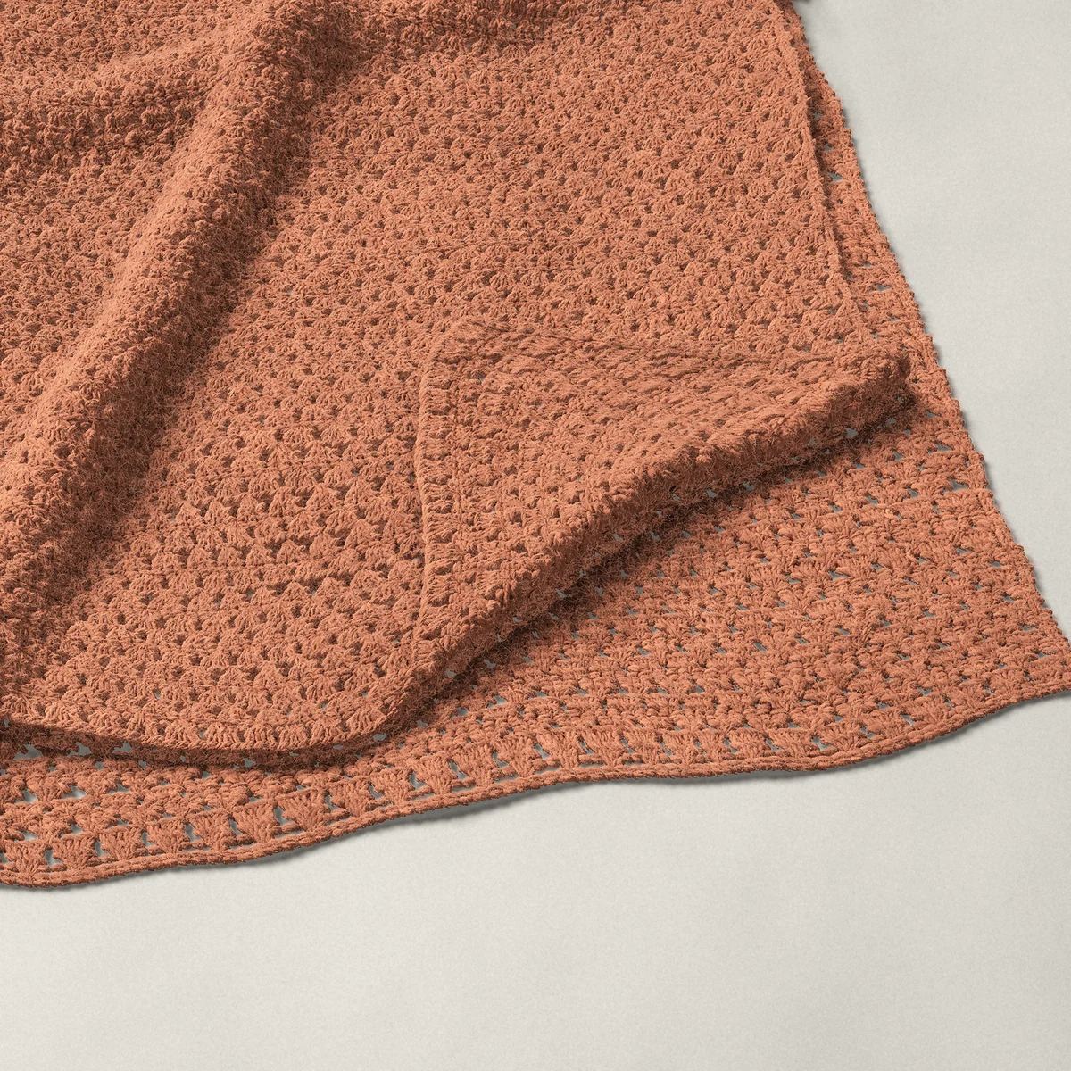 A throw in granny stripe, 50½ by 60¼ inches, folded in half with a corner turned back