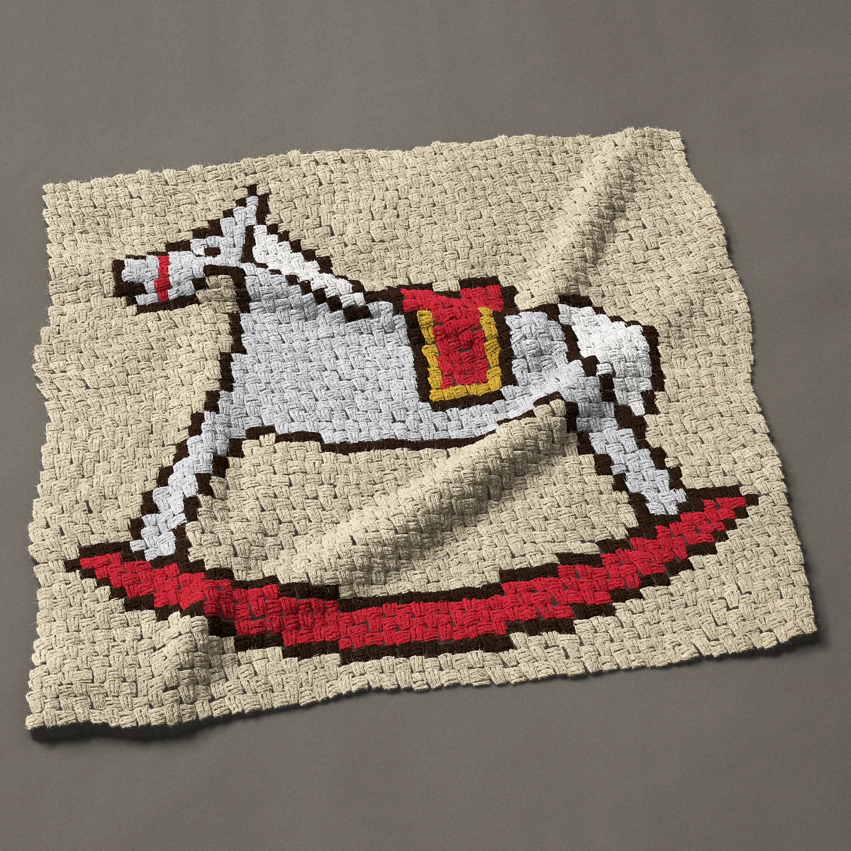 A baby blanket worked corner to corner, 40½ by 37½ inches: Gray rocking horse with a red saddle on red rockers, 54 by 50 blocks