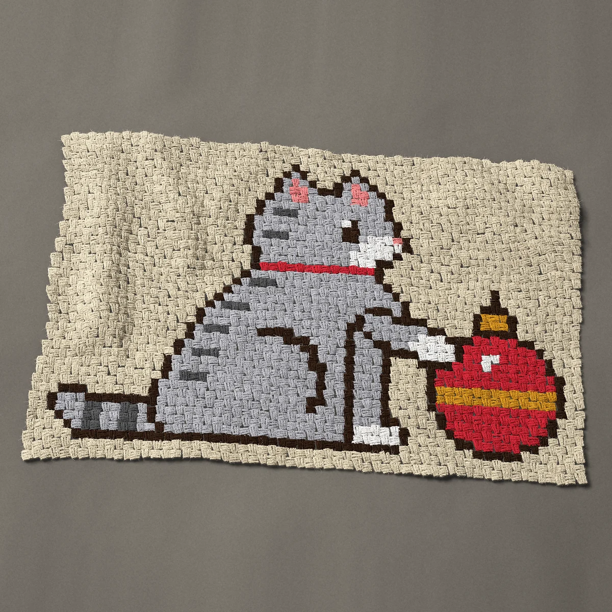A baby blanket worked corner to corner, 45 by 29¼ inches: Christmas cat: gray tabby with a paw on a red ornament, 60 by 39 blocks