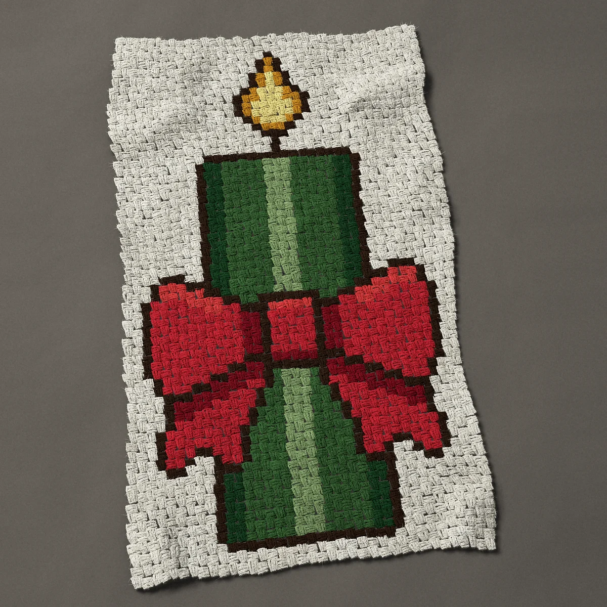 A baby blanket worked corner to corner, 27¾ by 48 inches: Green Christmas candle tied with a red bow, 37 by 64 blocks