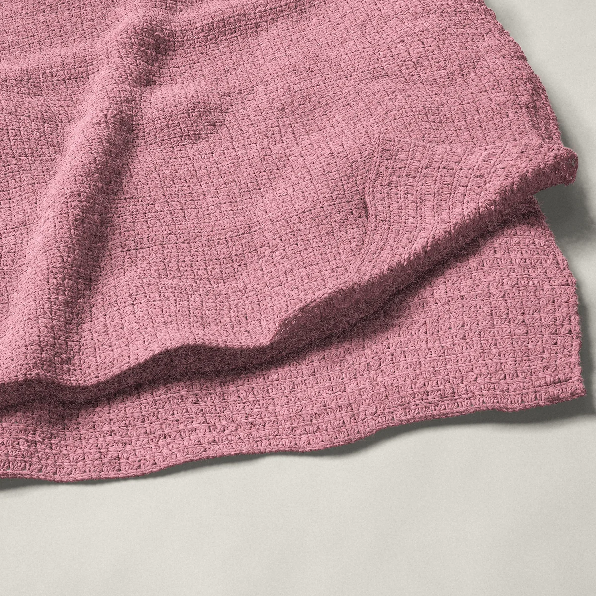 A throw in grit stitch, 54¼ by 66 inches, folded in half with a corner turned back