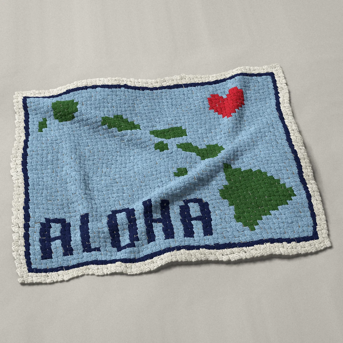 A lap blanket worked corner to corner, 48 by 37½ inches: Hawaii map of the Hawaiian islands with Aloha, 64 by 50 blocks