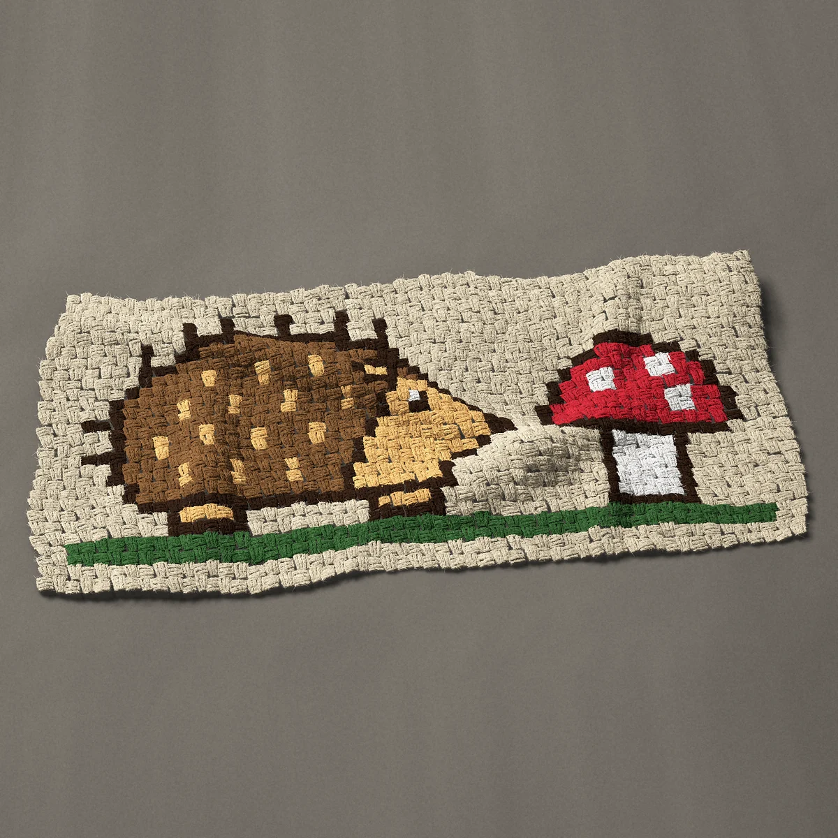 A panel worked corner to corner, 42 by 20¼ inches: Hedgehog with a red and white spotted toadstool, 56 by 27 blocks