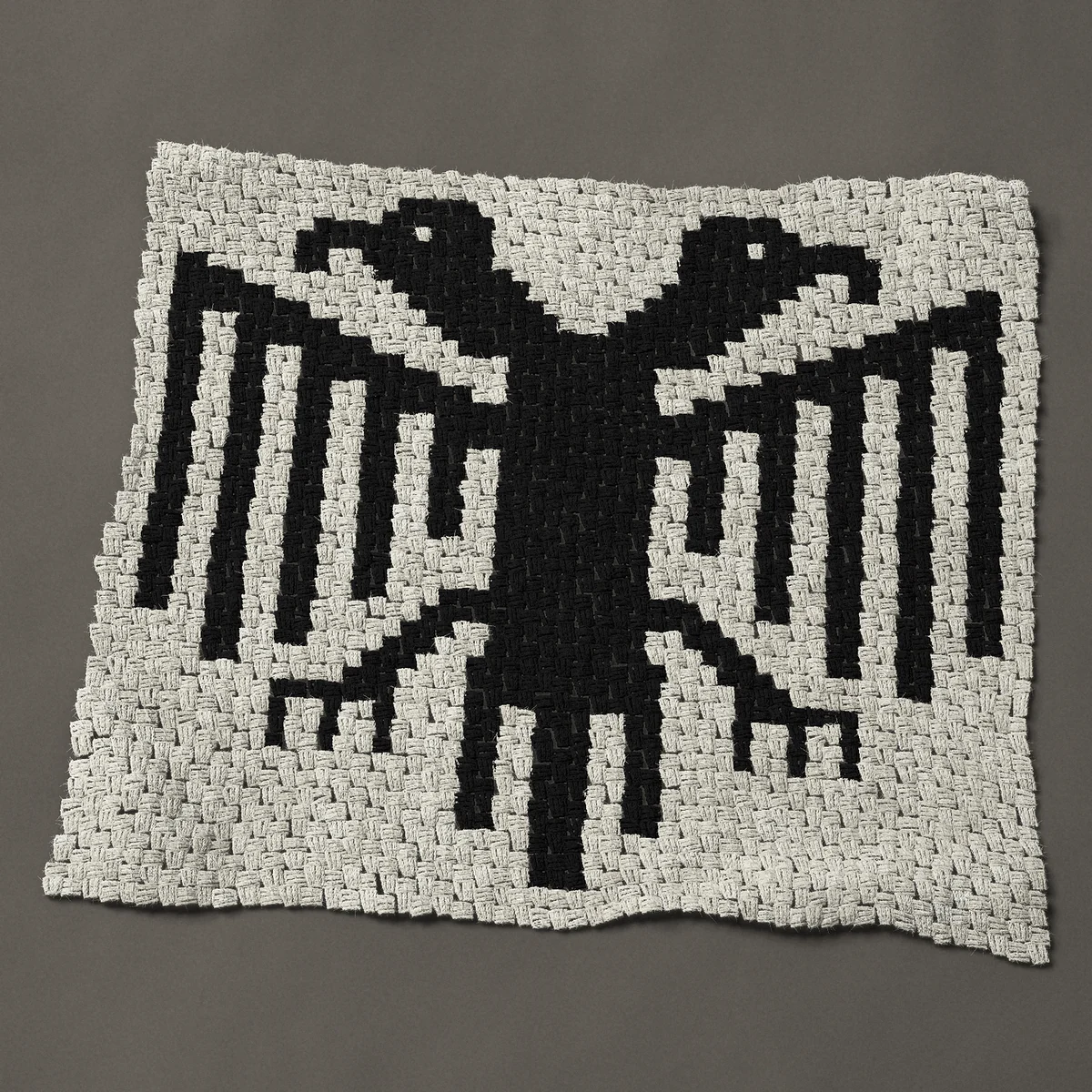 A baby blanket worked corner to corner, 39½ by 35¼ inches: Heraldic double-headed eagle in one color, 53 by 47 blocks