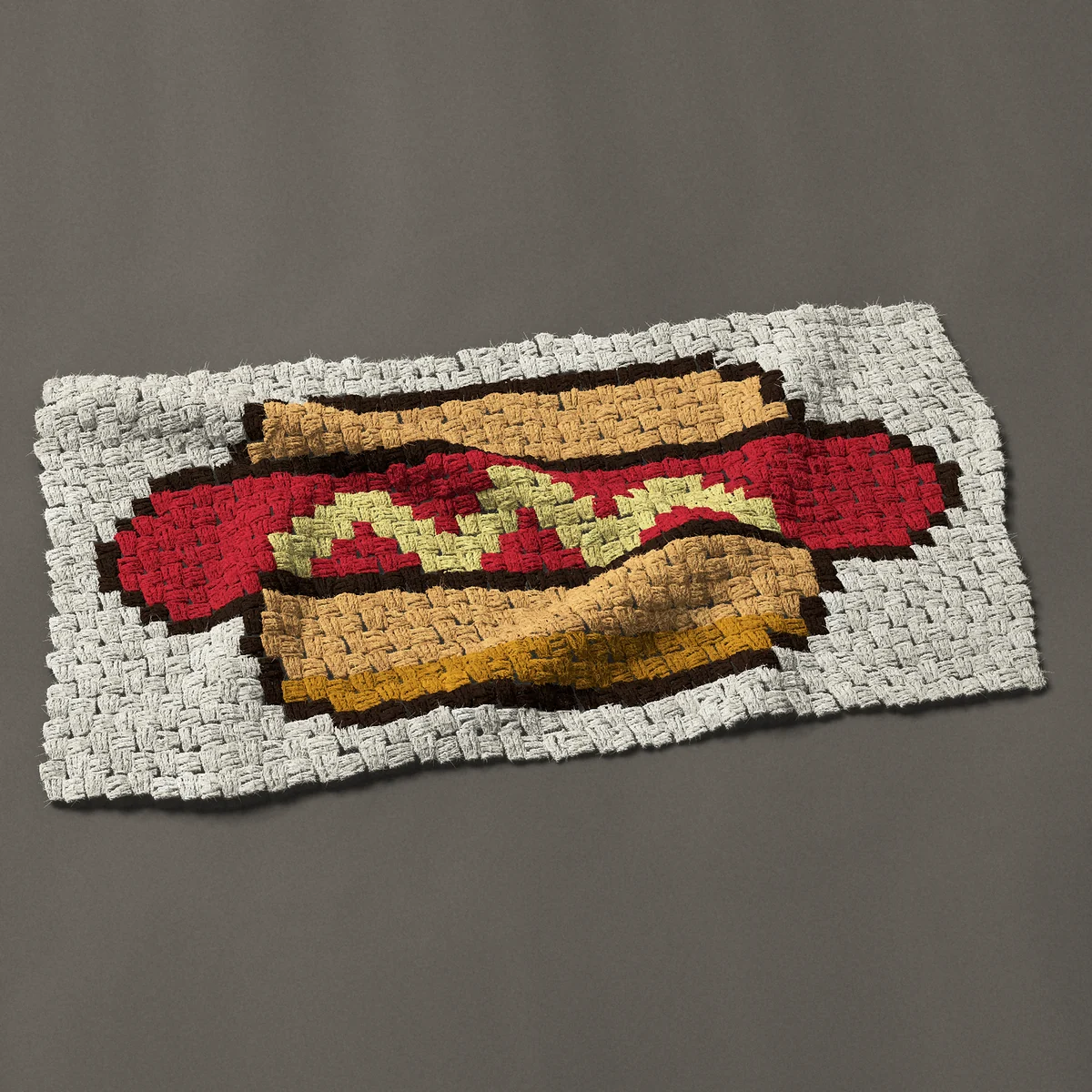 A panel worked corner to corner, 35¼ by 18 inches: Hot dog in a bun with a mustard zigzag, 47 by 24 blocks