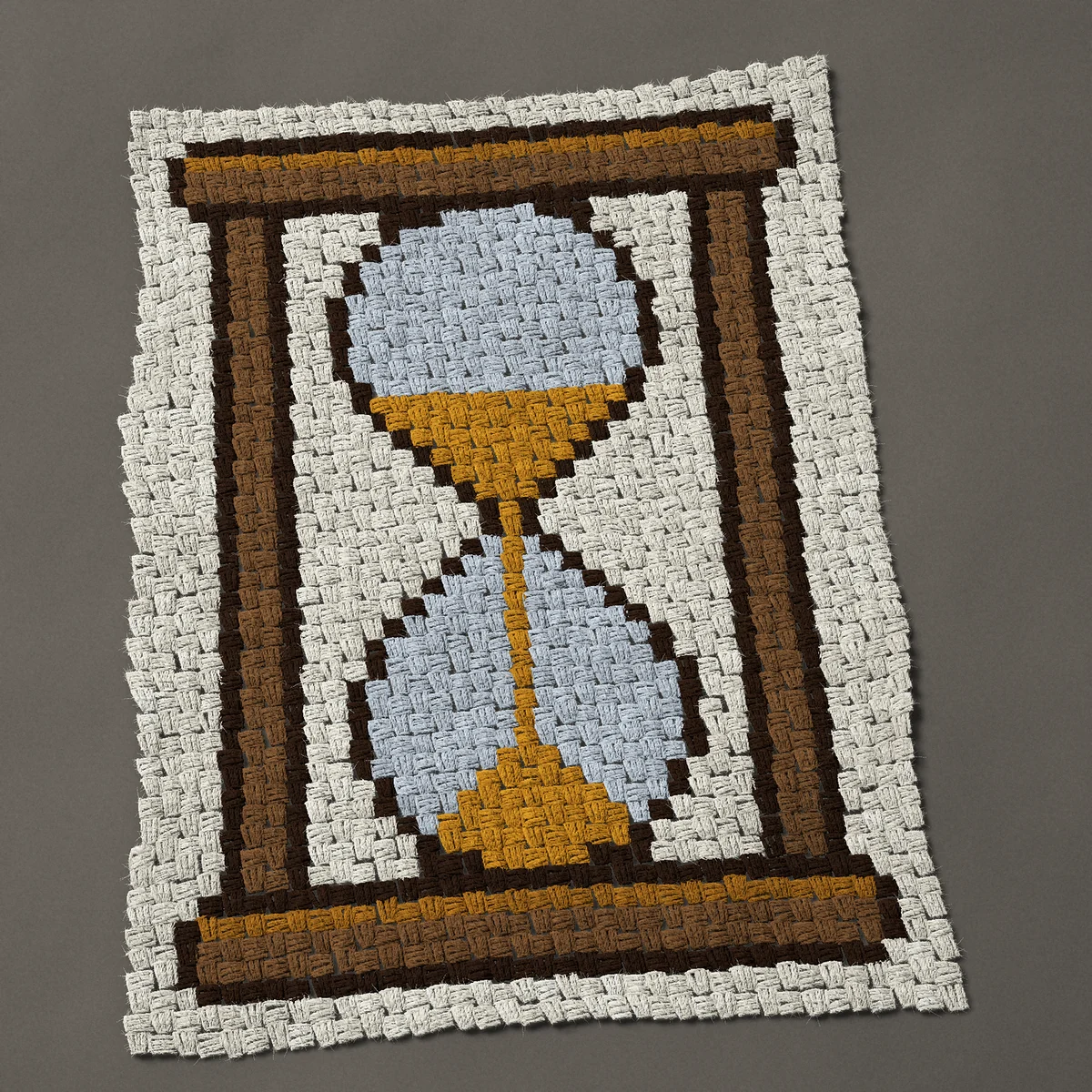 A baby blanket worked corner to corner, 27¾ by 37½ inches: Hourglass in a wooden stand with sand falling, 37 by 50 blocks