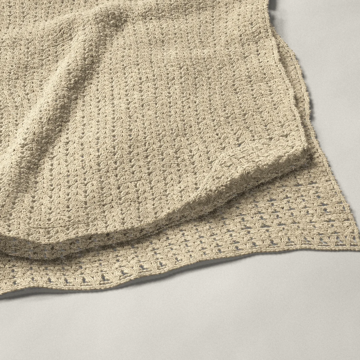 A throw in iris stitch, 54½ by 66 inches, folded in half with a corner turned back