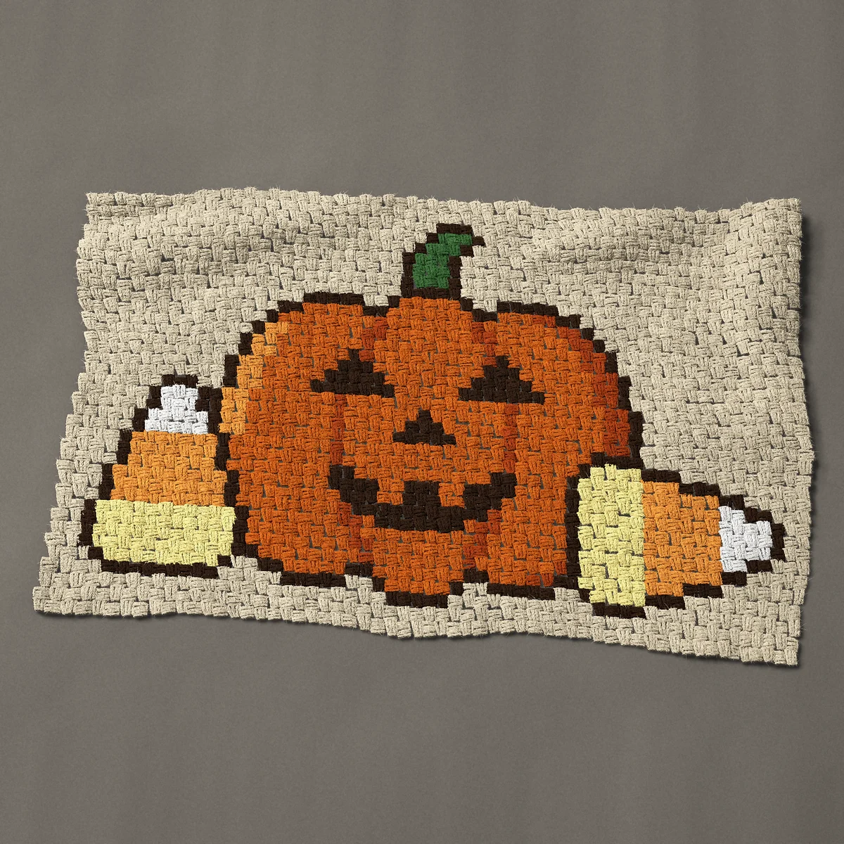 A baby blanket worked corner to corner, 44 by 27¾ inches: Jack o lantern pumpkin with two pieces of candy corn, 59 by 37 blocks