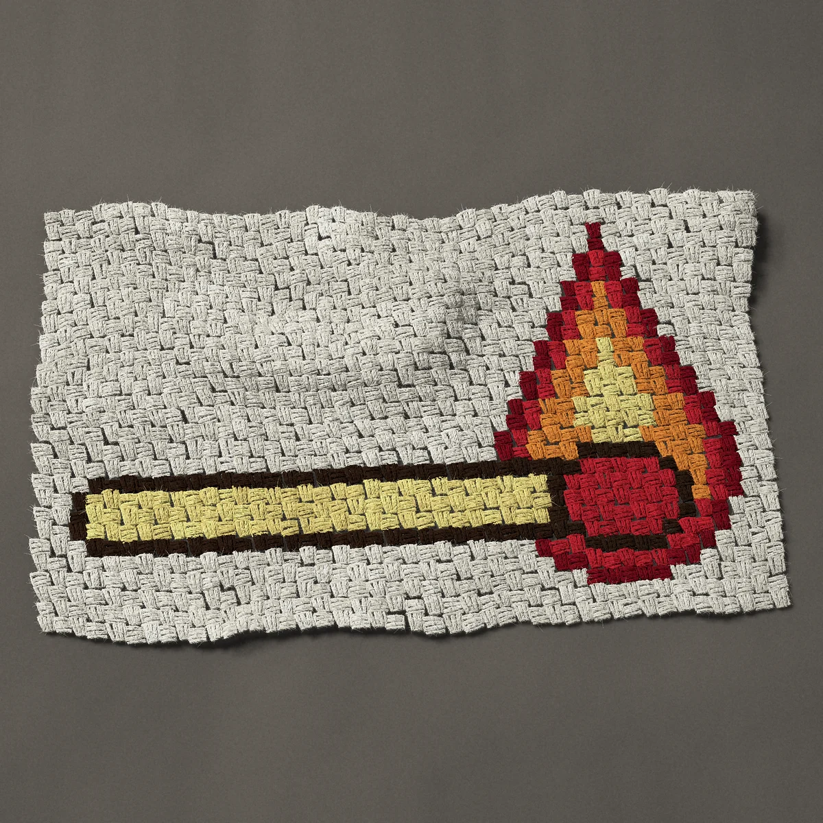 A panel worked corner to corner, 33¾ by 21 inches: Lit match, a burning match with a red head and flame, 45 by 28 blocks