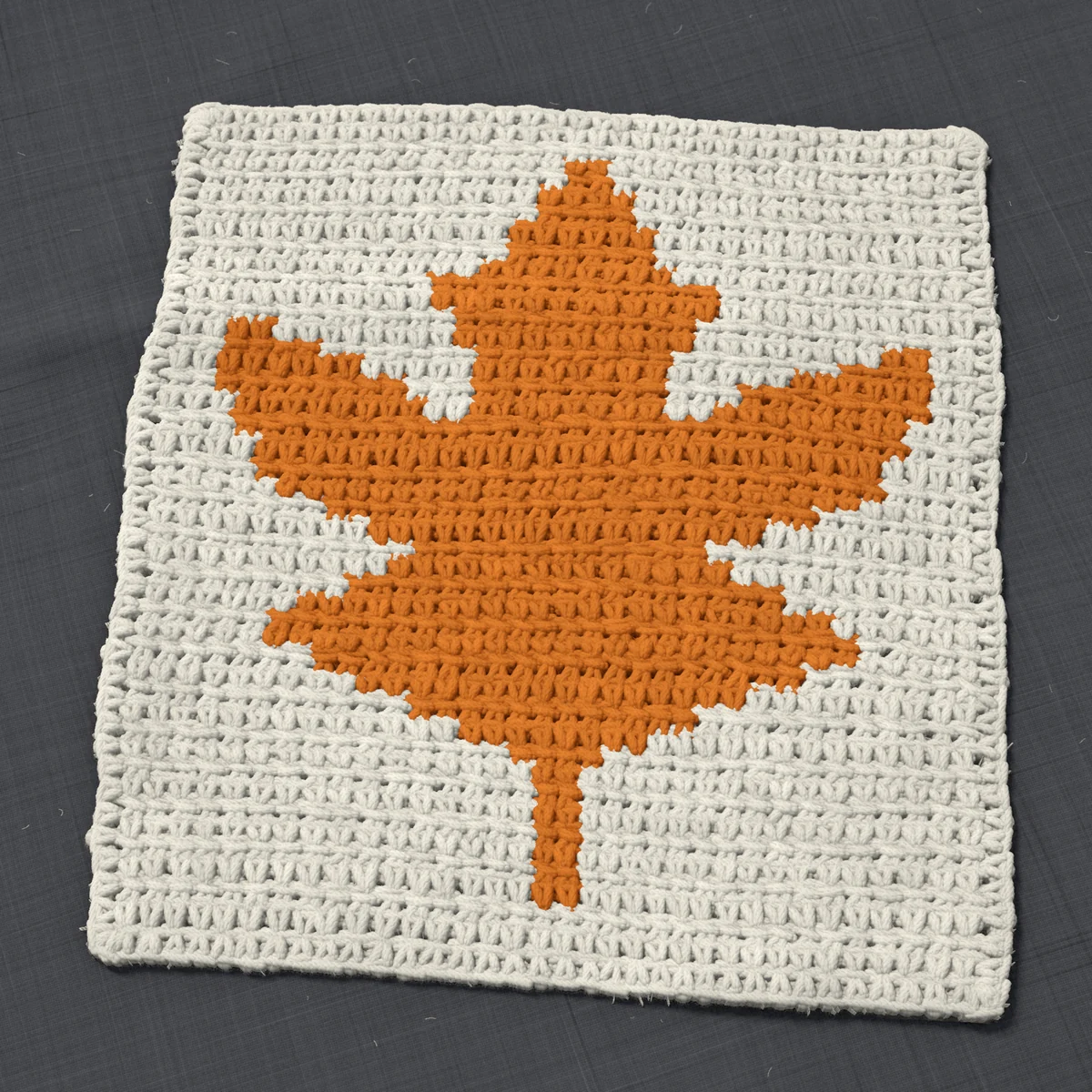 A washcloth in single crochet, 10.5 by 11.5 inches: a maple leaf in orange on a cream ground, 34 stitches by 43 rows