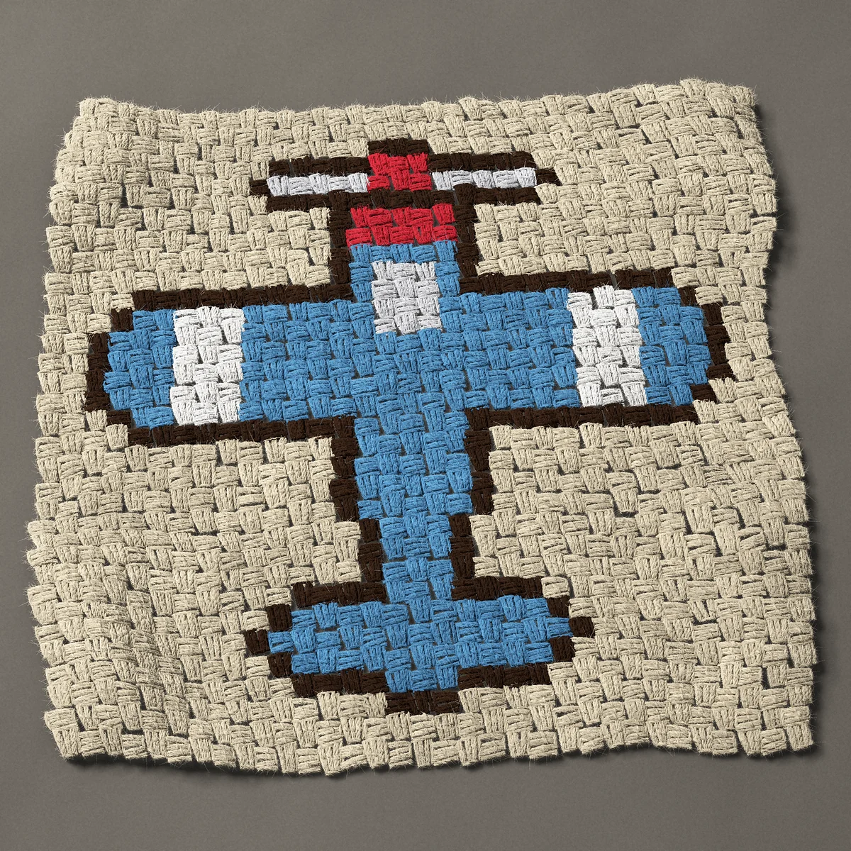 A panel worked corner to corner, 24¾ by 24¾ inches: Blue propeller airplane seen from above, 33 by 33 blocks
