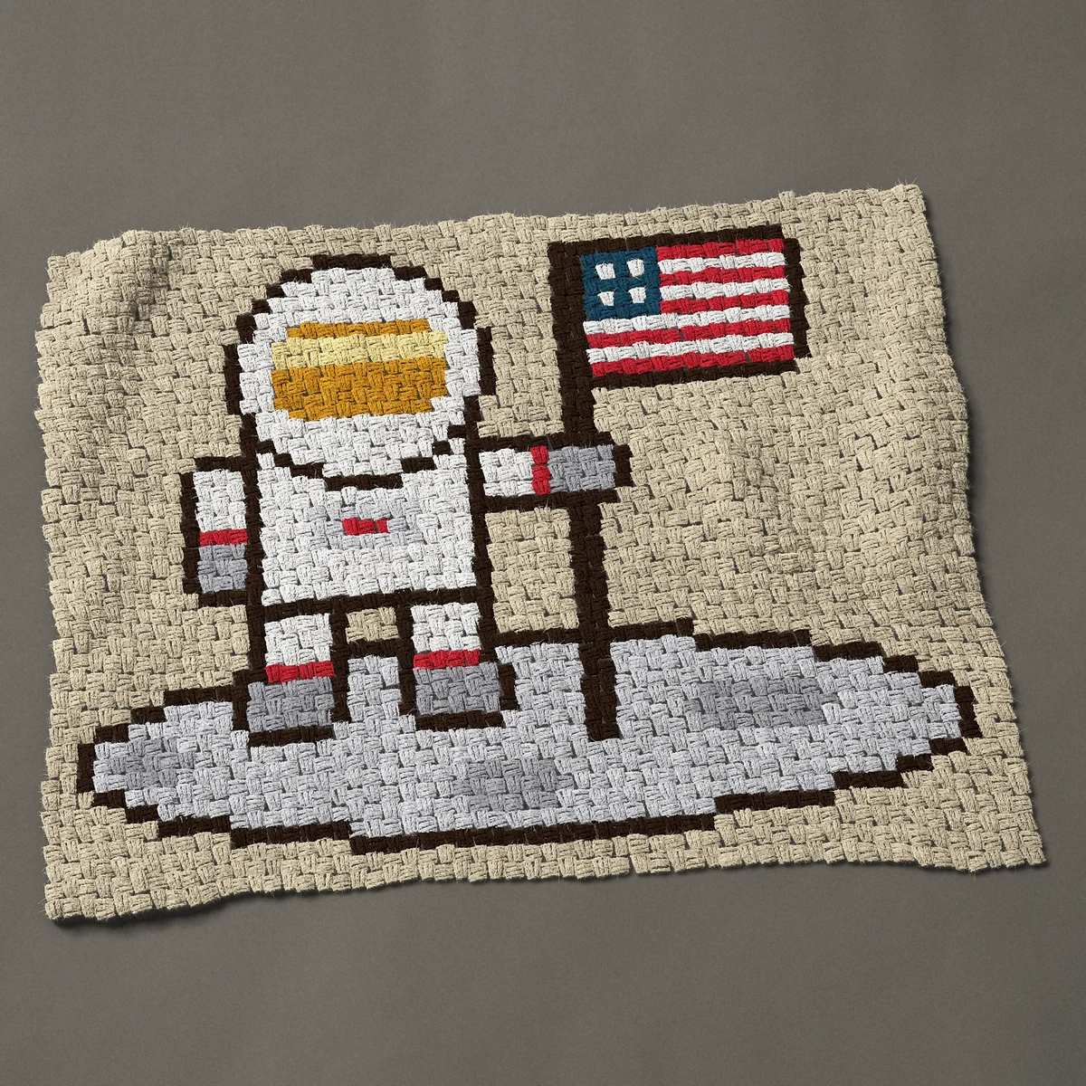 A baby blanket worked corner to corner, 42½ by 33 inches: Moon landing astronaut holding an American flag, 57 by 44 blocks