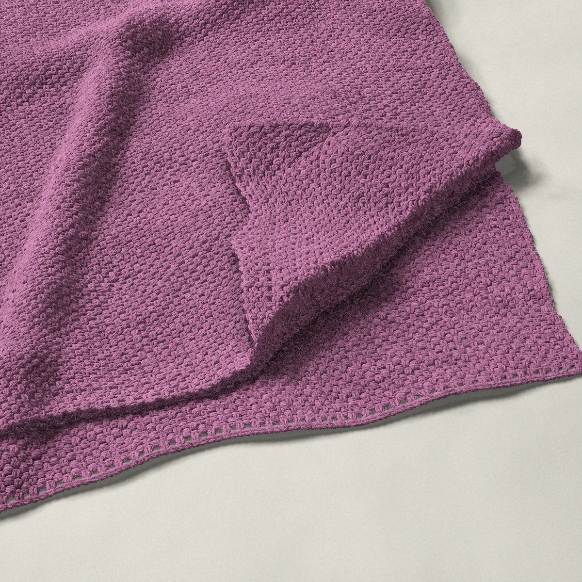 A throw in moss stitch, 54¼ by 66 inches, folded in half with a corner turned back