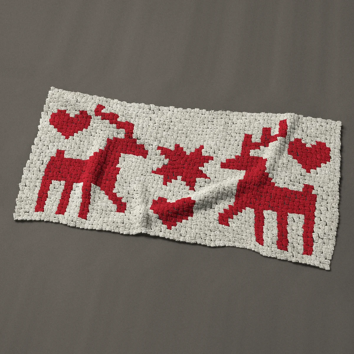 A baby blanket worked corner to corner, 51½ by 27¾ inches: Nordic red reindeer pair with a star and hearts, 69 by 37 blocks