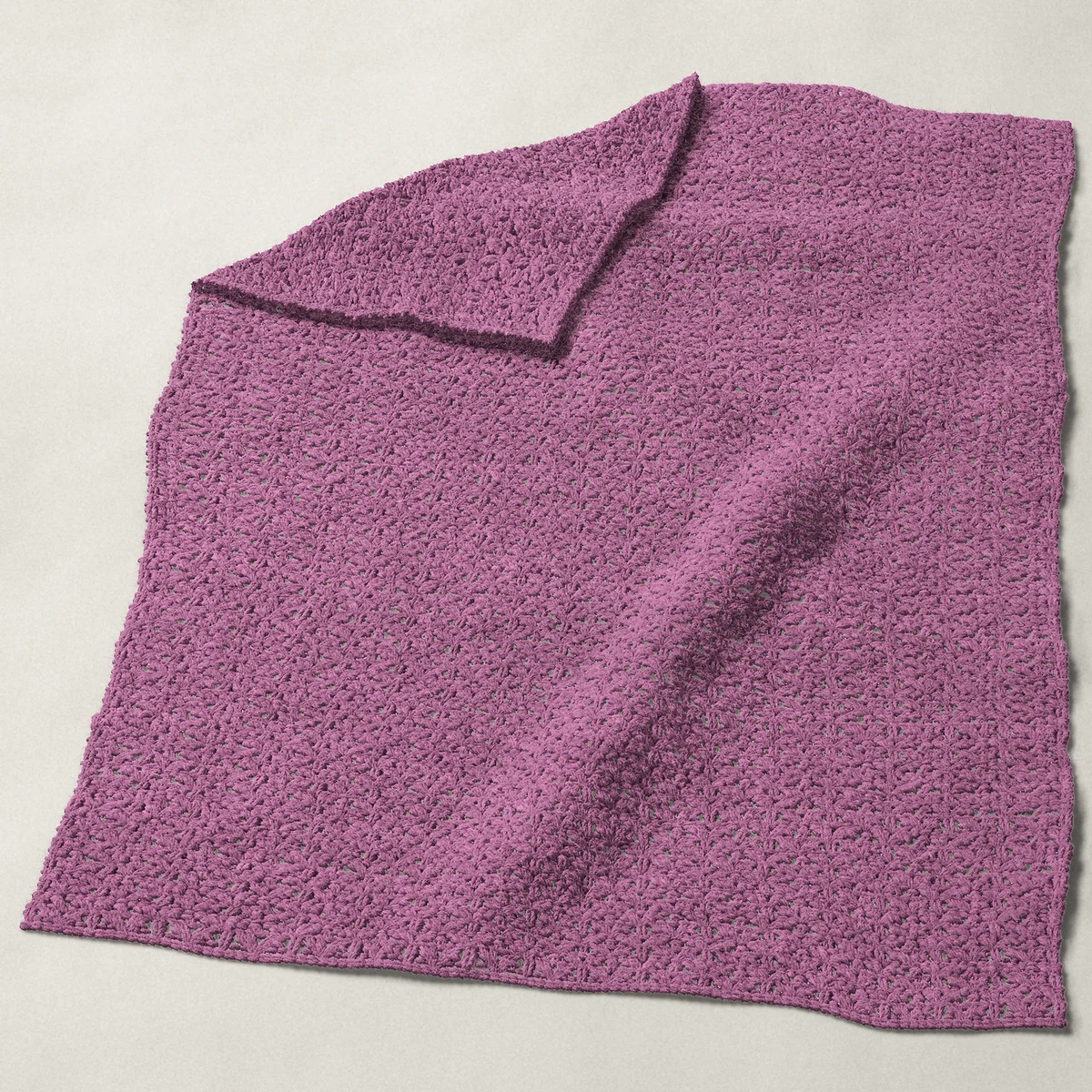 A baby blanket in open shell stitch, 31¾ by 40½ inches, spread out with a corner turned over