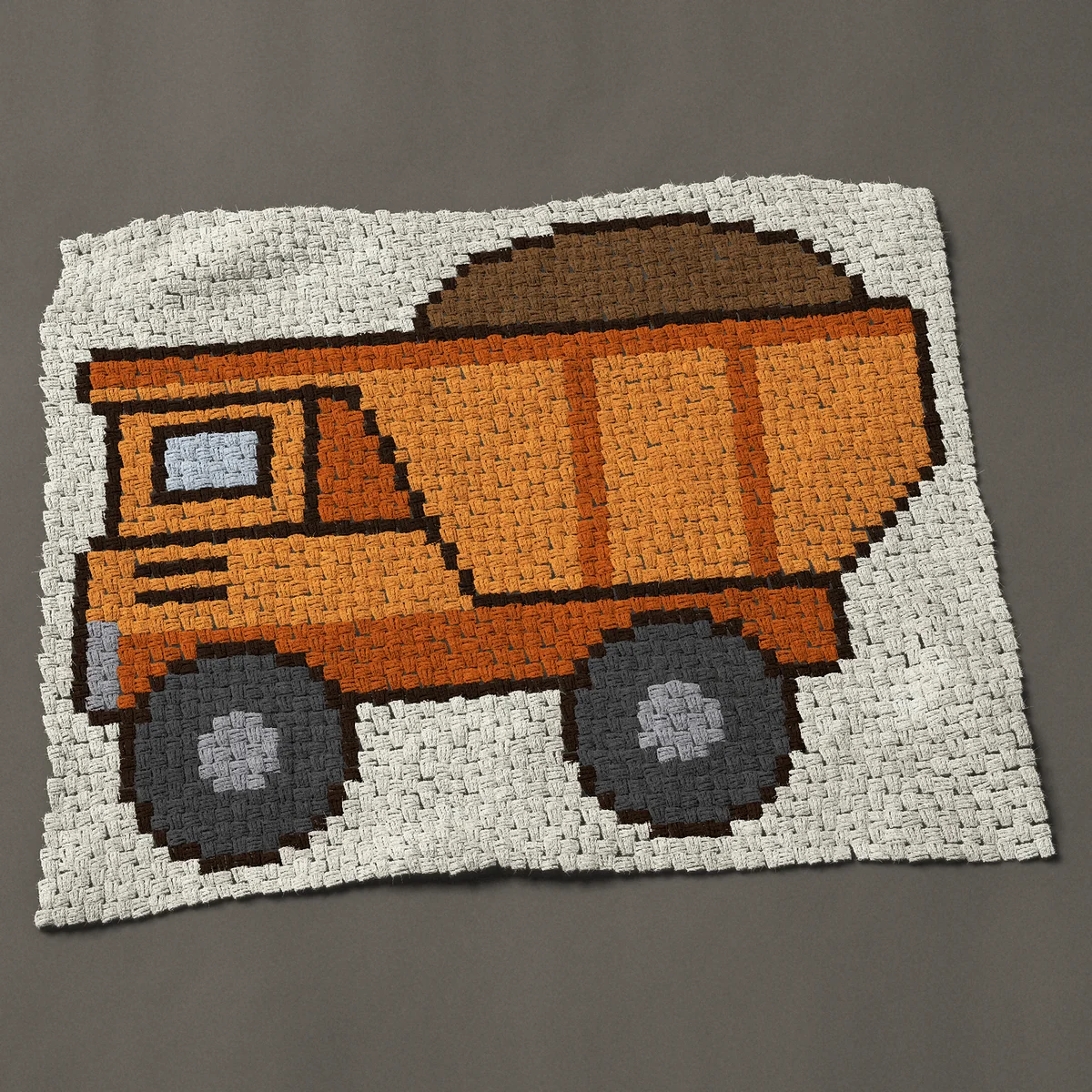 A lap blanket worked corner to corner, 46½ by 36¾ inches: Orange dump truck hauling dirt, a construction vehicle, 62 by 49 blocks