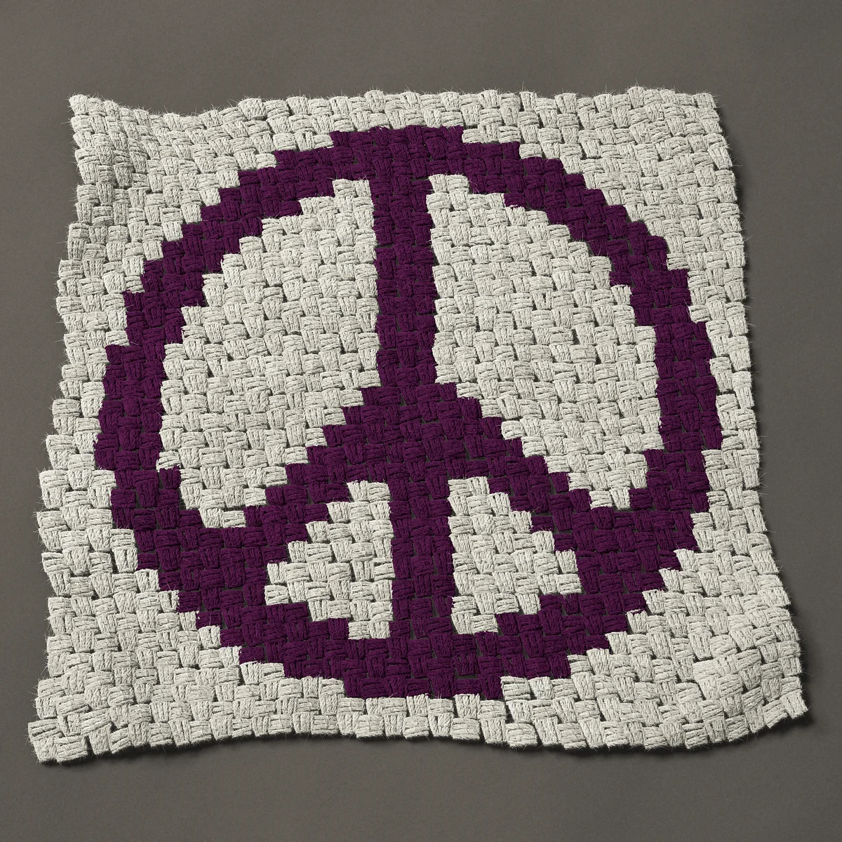 A panel worked corner to corner, 26¼ by 26¼ inches: Peace sign in one color, bold purple, 35 by 35 blocks